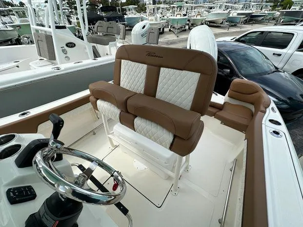 Slide: The Image of 2024 Pioneer 202 Islander boat interior with brown and white seating, steering wheel, and control panel. - 7