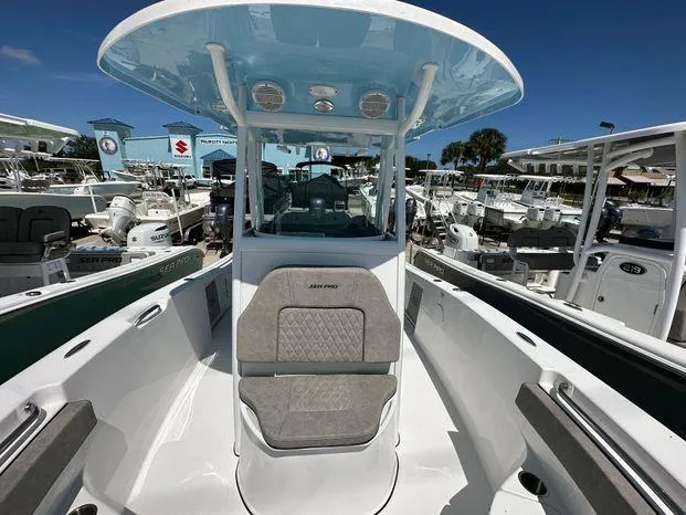 Slide: The Image of 2024 Sea Pro 239 Sport boat interior with seating and console, docked at a marina. - 6