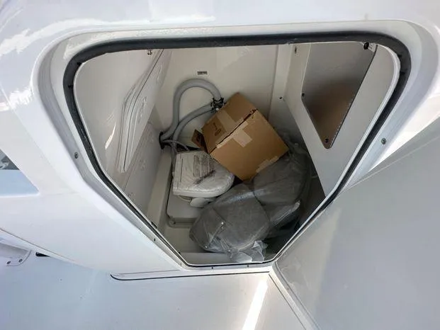 Slide: The Image of 2024 Sea Pro 239 Sport storage compartment with cardboard box and equipment. - 7