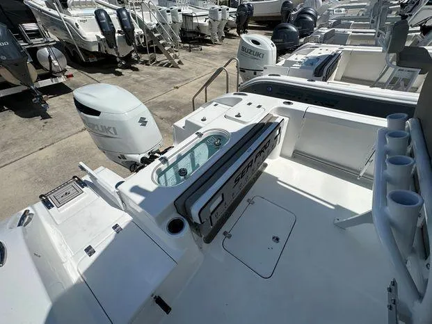 Slide: The Image of 2024 Sea Pro 239 Sport boat with Suzuki outboard motor in a marina. - 9