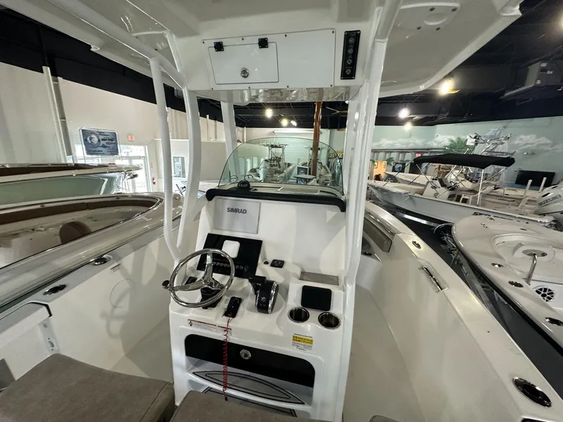 Slide: The Image of 2024 Sea Pro 239 Sport boat interior with steering console and Simrad electronics. - 4