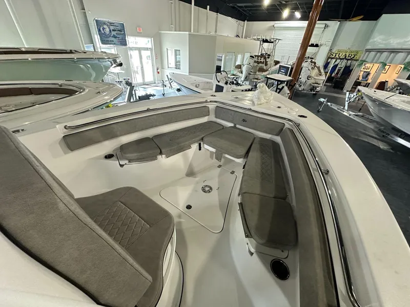 Slide: The Image of 2024 Sea Pro 239 Sport boat interior with cushioned seating in showroom. - 5