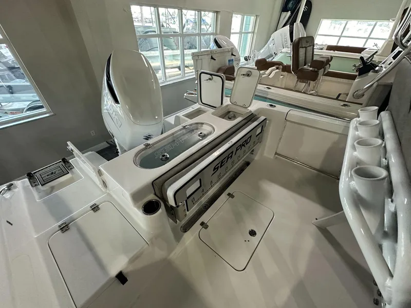 Slide: The Image of 2024 Sea Pro 239 Sport boat interior with Suzuki outboard motor and fishing rod holders. - 9