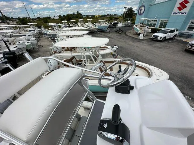 Slide: The Image of 2024 Avenger 26 Avenger boat at a dealership with multiple boats in the background. - 10