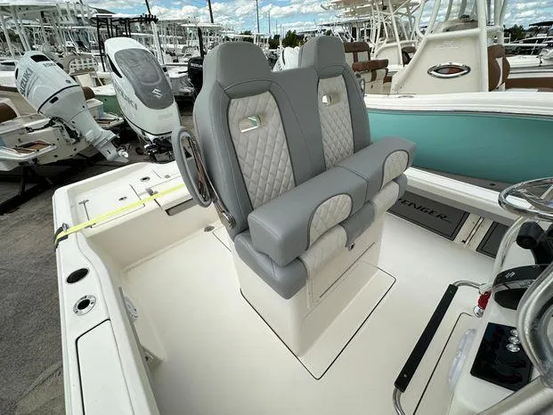 Slide: The Image of 2024 Avenger 26 boat with dual captain's chairs at marina. - 8