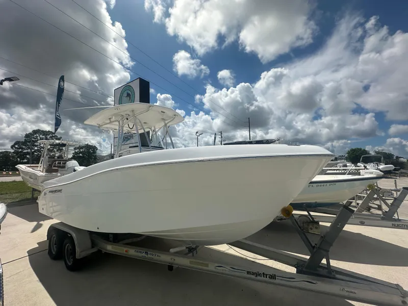 Slide: The Image of 2022 Aquasport 2300 boat on trailer under cloudy sky. - 2