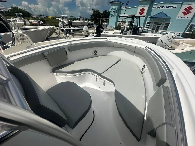 Slide: The Image of 2022 Aquasport 2300 boat interior with cushioned seating, displayed at Palm City Yachts. - 5