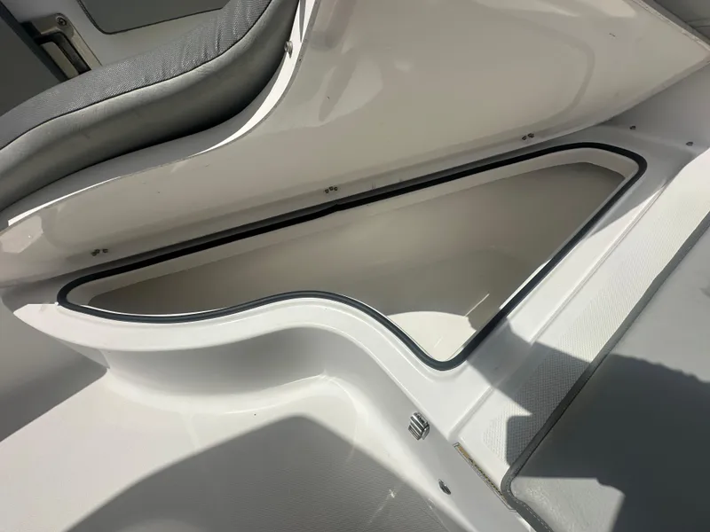 Slide: The Image of Open storage compartment in 2022 Aquasport 2300 boat, featuring cushioned seating. - 7
