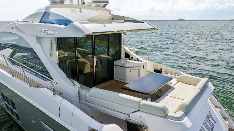 Slide: The Image of 2016 Azimut 55S luxury yacht with spacious deck and seating area on the water. - 12