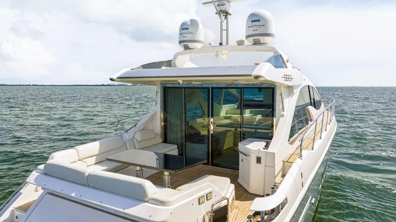 Slide: The Image of 2016 Azimut 55S yacht on open water, rear view showing deck and seating area. - 14