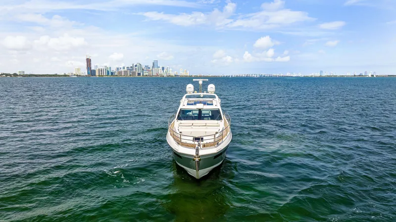 Slide: The Image of 2016 Azimut 55S yacht on open water with city skyline in background. - 2