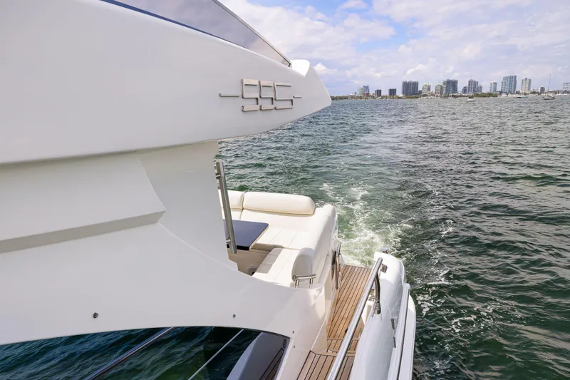 Slide: The Image of 2016 Azimut 55S yacht cruising on open water with city skyline in the background. - 24