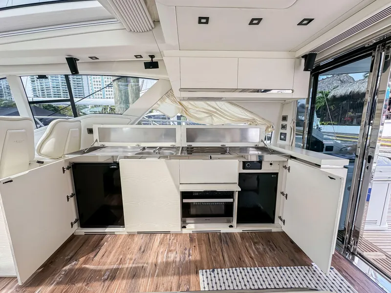 Slide: The Image of Modern kitchen area on a 2016 Azimut 55S yacht with open cabinets and wood flooring. - 32