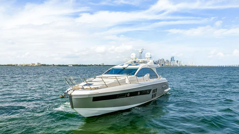 Slide: The Image of 2016 Azimut 55S yacht cruising on open water with city skyline in background. - 4