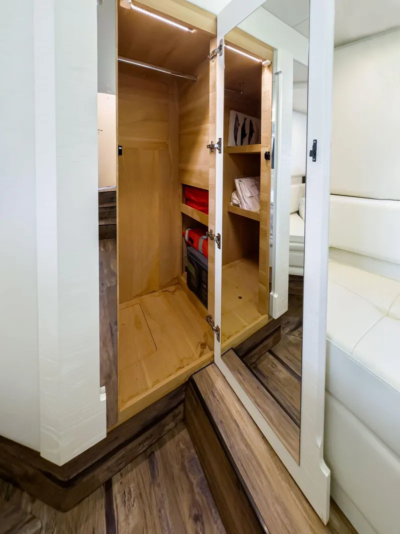 Slide: The Image of 2016 Azimut 55S yacht interior with open wooden closet and mirrored door. - 47