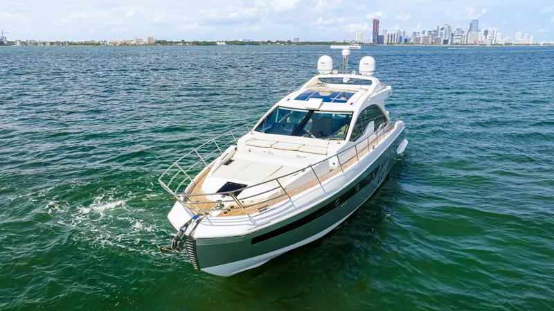 Slide: The Image of 2016 Azimut 55S yacht cruising on open water with city skyline in background. - 8