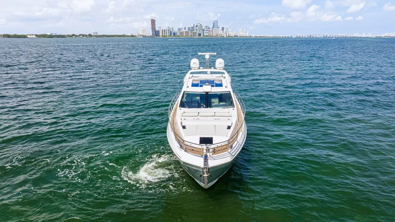 Slide: The Image of 2016 Azimut 55S yacht cruising on open water with city skyline in the background. - 9