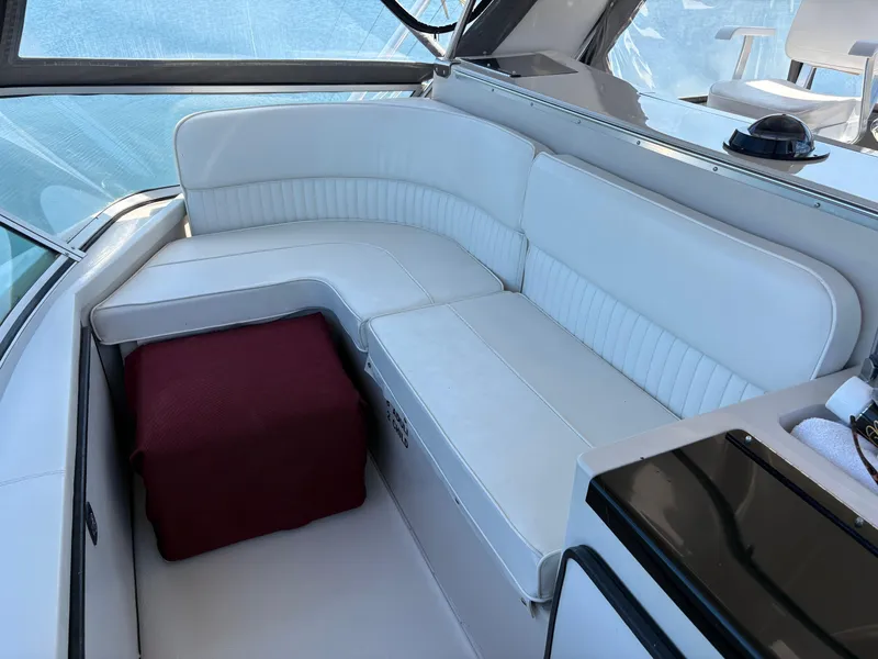 Slide: The Image of White seating area on 1987 Sea Ray 460 Convertible yacht, featuring a red cushion. - 10