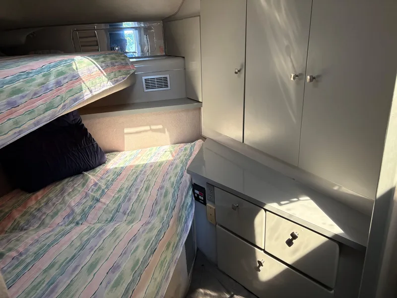 Slide: The Image of Interior cabin of 1987 Sea Ray 460 Convertible with bunk beds and storage cabinets. - 17