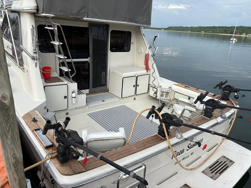 Slide: The Image of 1987 Sea Ray 460 Convertible yacht with fishing gear, docked on calm water. - 2