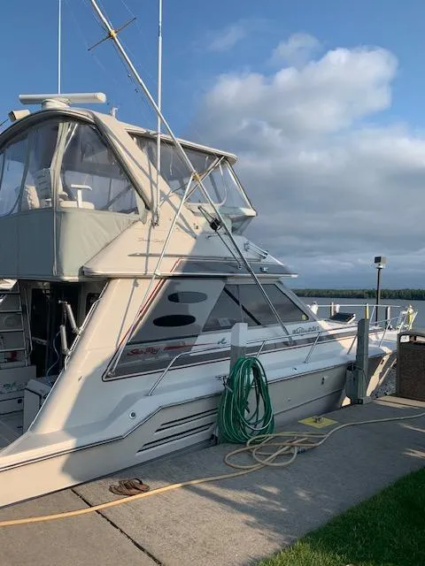 Slide: The Image of 1987 Sea Ray 460 Convertible yacht docked, with clear skies and coiled hose on deck. - 22