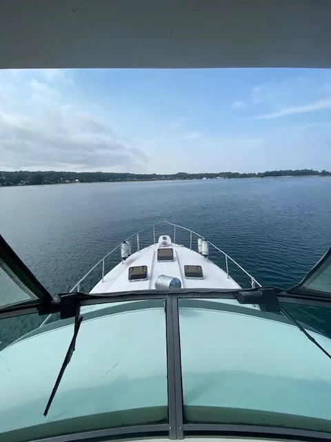 Slide: The Image of 1987 Sea Ray 460 Convertible yacht cruising on calm waters under a clear sky. - 26