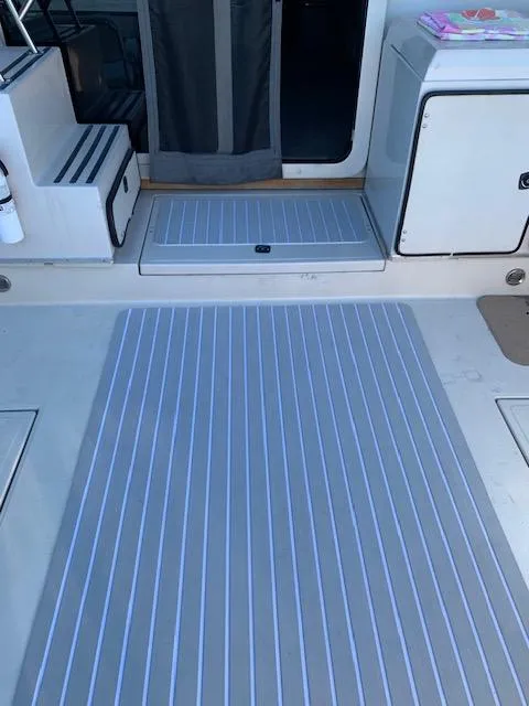 Slide: The Image of 1987 Sea Ray 460 Convertible boat deck with striped flooring and storage compartments. - 30