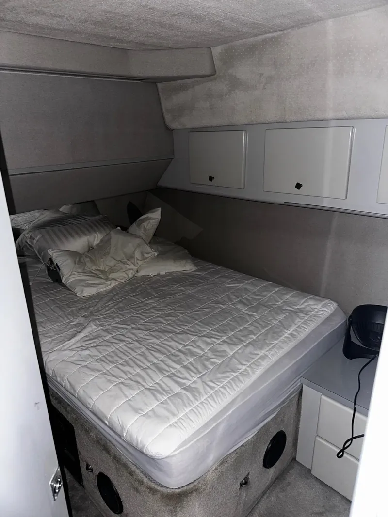 Slide: The Image of 1987 Sea Ray 460 Convertible cabin with bed, storage cabinets, and modern decor. - 35