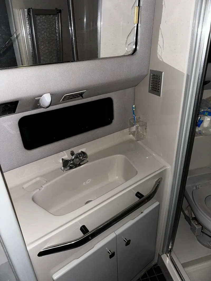 Slide: The Image of 1987 Sea Ray 460 Convertible bathroom with sink, mirror, and shower area. - 38