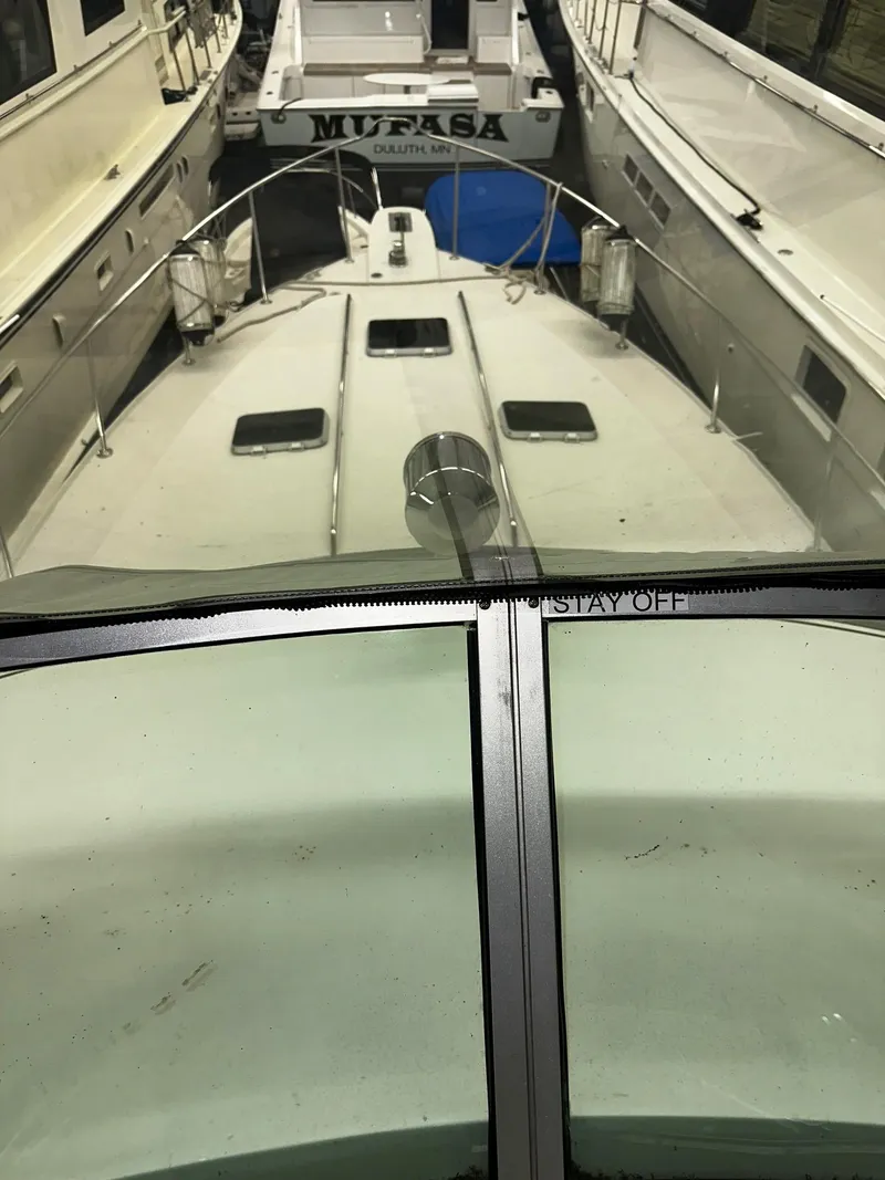 Slide: The Image of 1987 Sea Ray 460 Convertible yacht docked between two boats. - 45