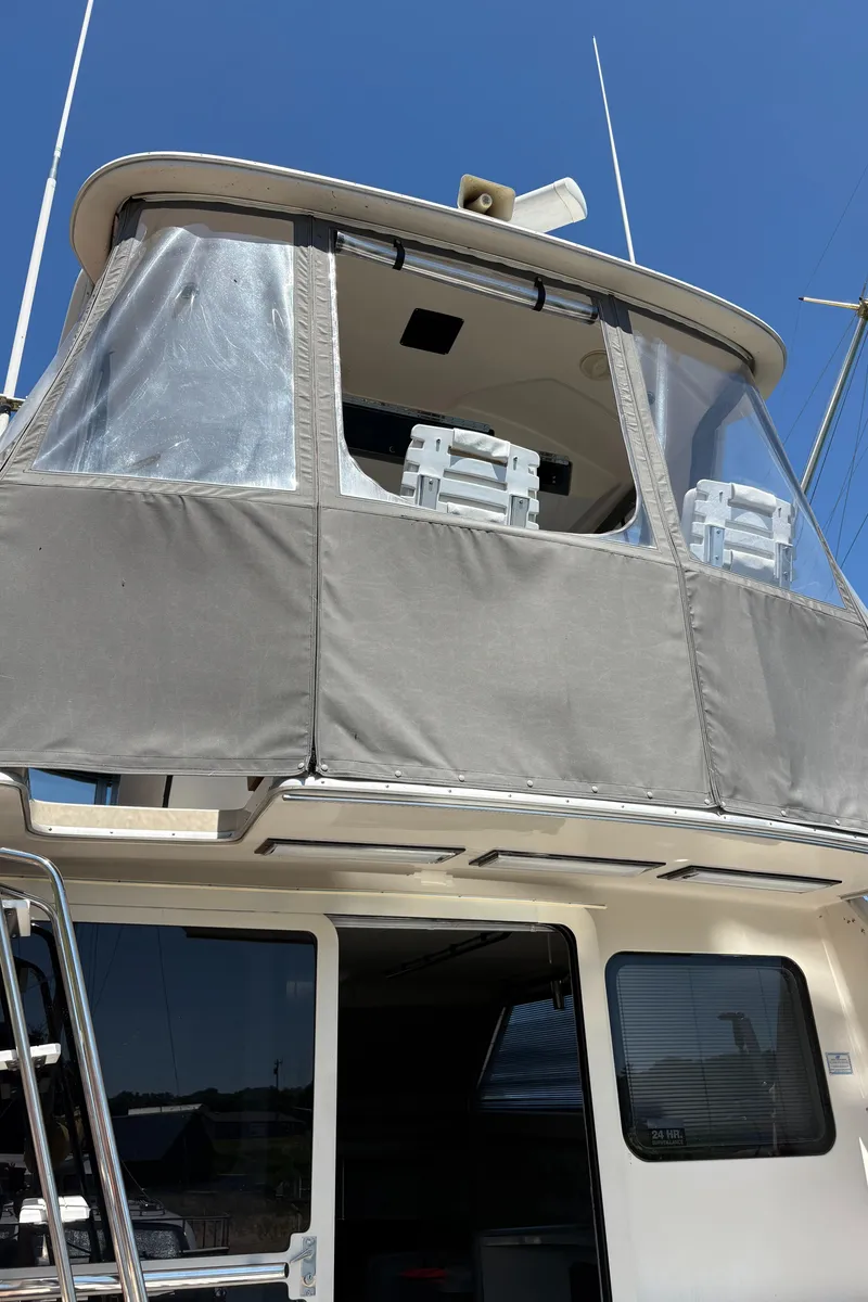 Slide: The Image of 1987 Sea Ray 460 Convertible boat with enclosed upper deck and clear windows. - 6