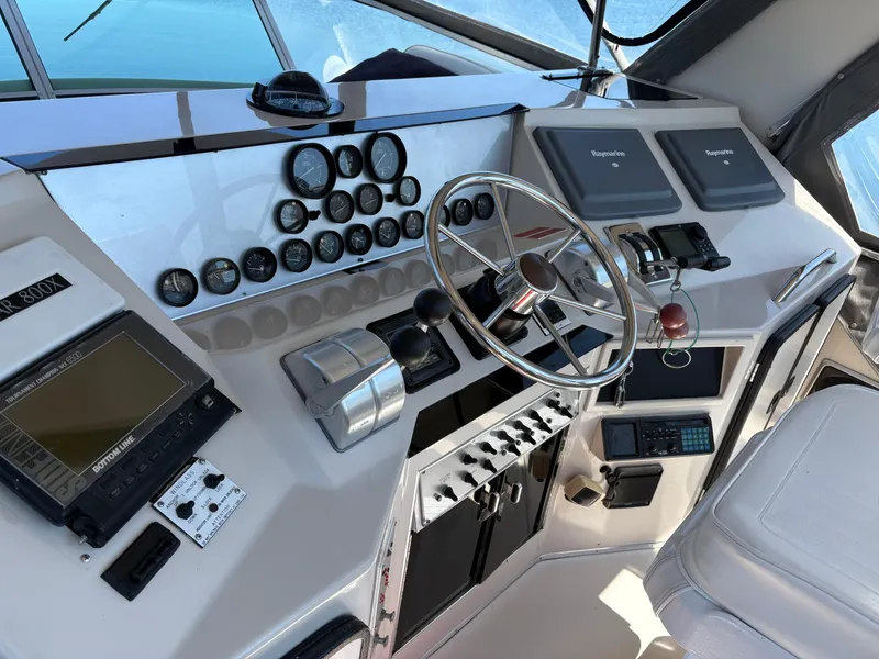 Slide: The Image of 1987 Sea Ray 460 Convertible yacht helm with gauges, steering wheel, and navigation equipment. - 7
