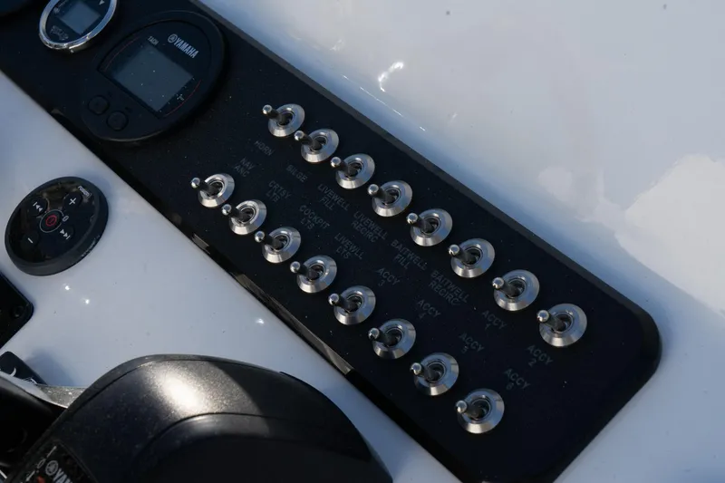 Slide: The Image of Control panel of 2024 Skeeter SX 210 boat with switches and gauges. - 13