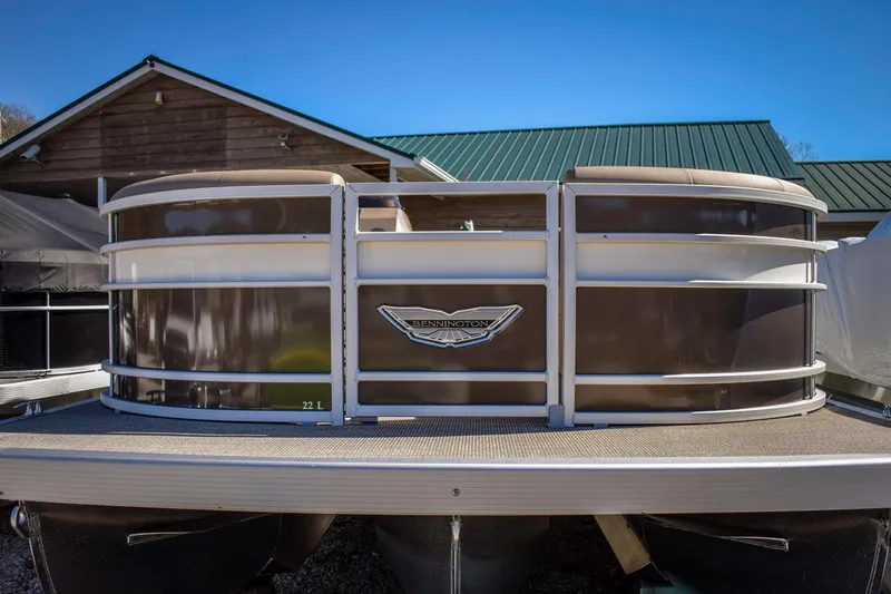 Slide: The Image of 2024 Bennington 22 LSB pontoon boat docked near a wooden building. - 15