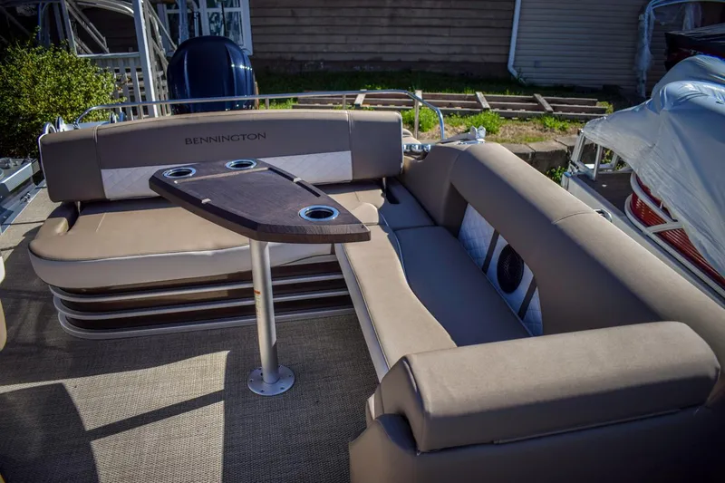 Slide: The Image of 2024 Bennington 22 LSB pontoon boat interior with plush seating and table. - 5