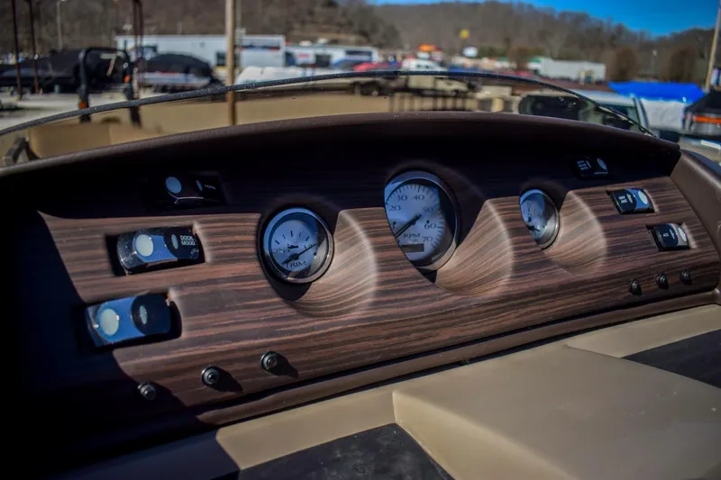 Slide: The Image of 2024 Bennington 22 LSB dashboard with wood finish and analog gauges. - 7
