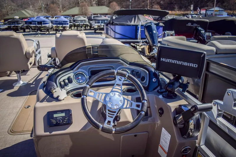 Slide: The Image of 2023 Sun Tracker Sportfish 24 XP3 boat dashboard with steering wheel and Humminbird fish finder. - 13