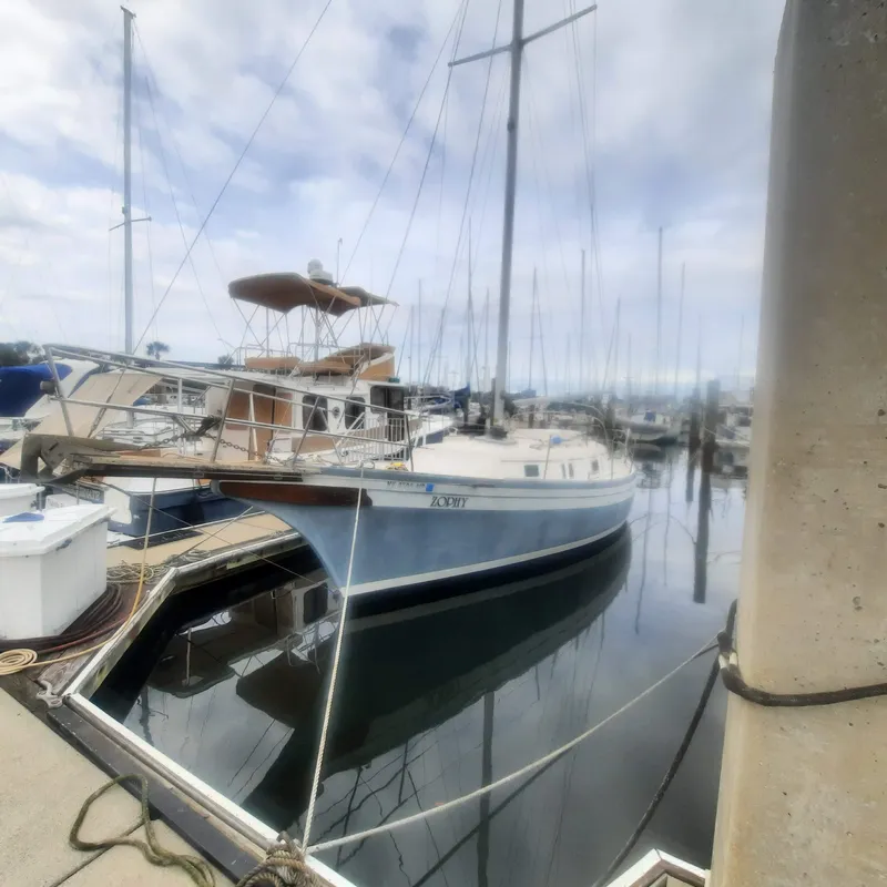 Slide: The Image of 1984 Bayfield 32C sailboat docked at a marina on a cloudy day. - 2