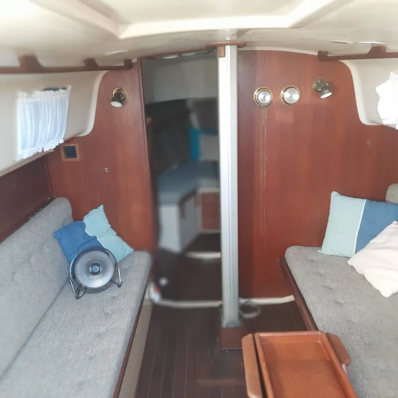 Slide: The Image of Interior of a 1984 Bayfield 32C sailboat with wooden paneling and cushioned seating. - 5