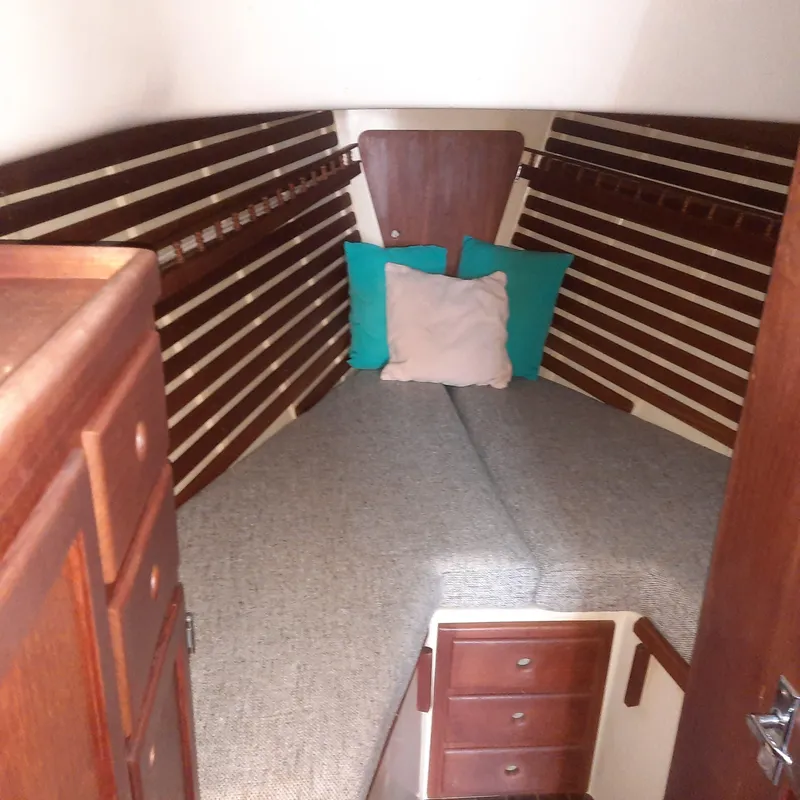 Slide: The Image of Cozy cabin interior of a 1984 Bayfield 32C sailboat with wooden accents and cushions. - 9