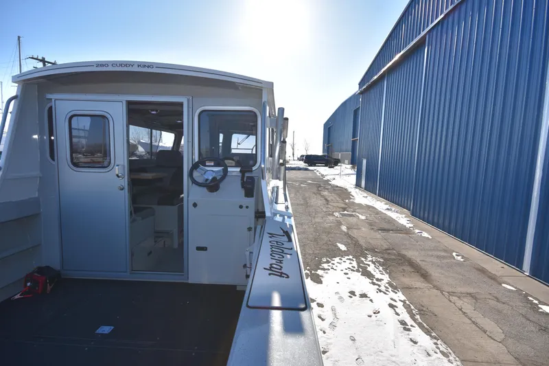 Slide: The Image of 2025 Weldcraft 280 Cuddy King T250XCB boat docked near blue warehouse. - 19