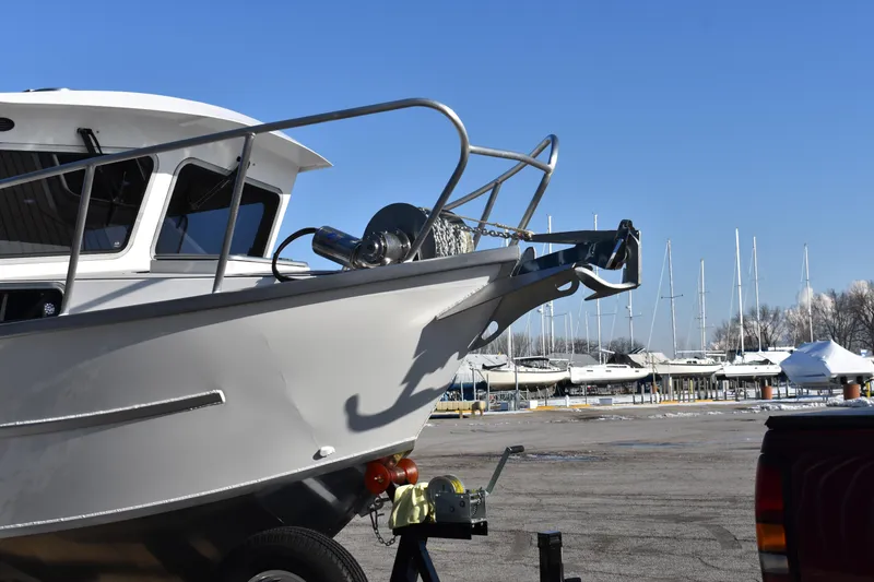 Slide: The Image of 2025 Weldcraft 280 Cuddy King T250XCB boat at marina with sailboats in background. - 3