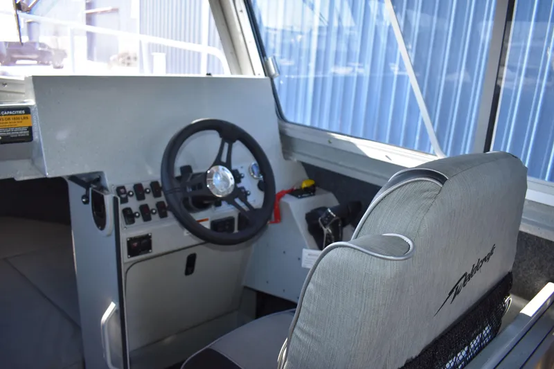 Slide: The Image of Interior helm of 2025 Weldcraft 280 Cuddy King boat with steering wheel and control panel. - 40