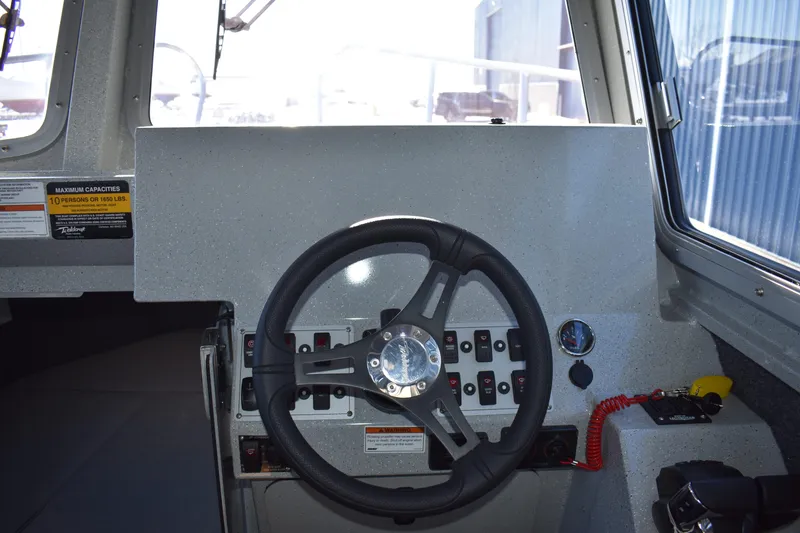 Slide: The Image of 2025 Weldcraft 280 Cuddy King T250XCB boat helm with steering wheel and control panel. - 41