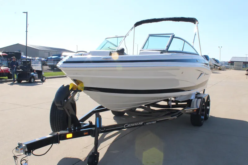 Slide: The Image of 2024 Crownline 220 SS boat on a trailer in a marina. - 12
