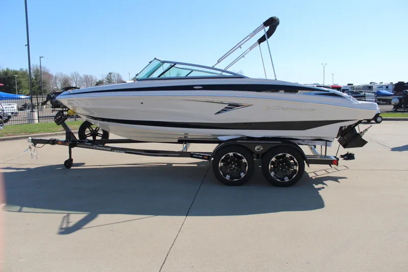 Slide: The Image of 2024 Crownline 220 SS boat on a trailer in a parking lot. - 15