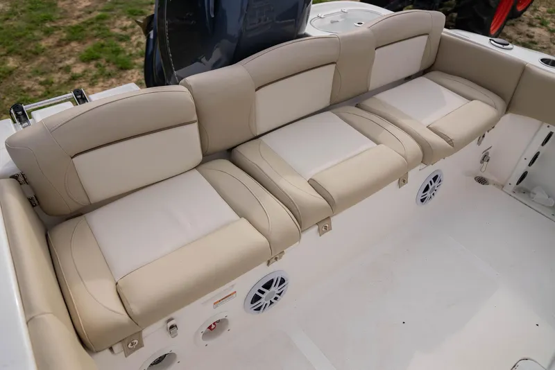 Slide: The Image of 2022 NauticStar 2102 Legacy boat with beige cushioned seating and built-in speakers. - 11