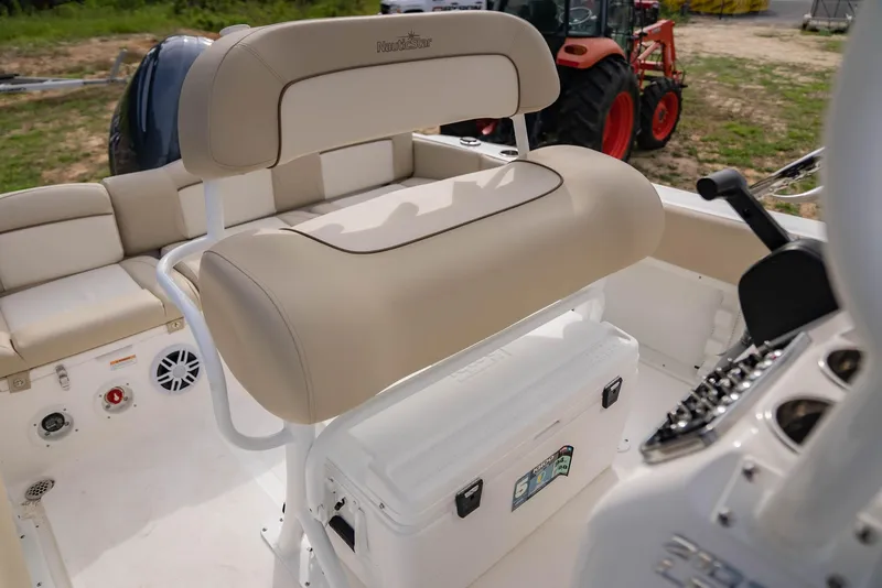 Slide: The Image of 2022 NauticStar 2102 Legacy boat interior with beige seating and control panel. - 12