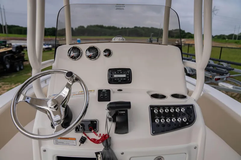 Slide: The Image of 2022 NauticStar 2102 Legacy boat dashboard with steering wheel and control panel. - 2