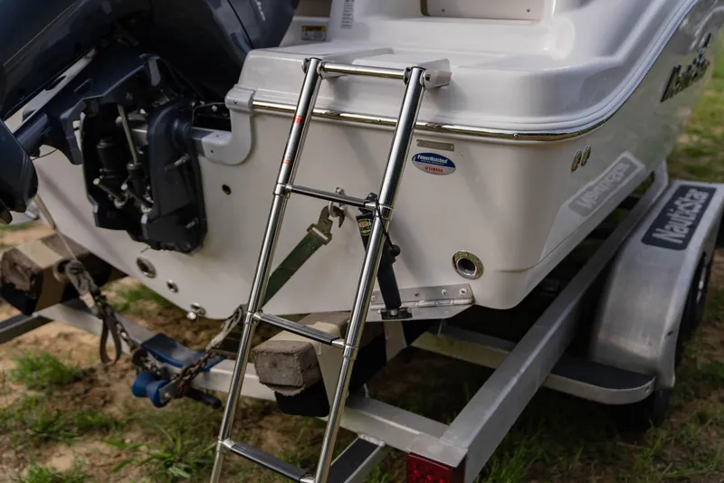 Slide: The Image of NauticStar 2102 Legacy 2022 boat on trailer with ladder and motor. - 6